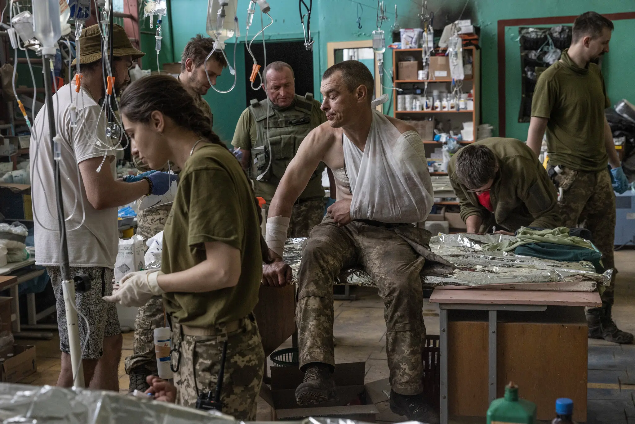 Медики 36-ї окремої бригади морської піхоти надають медичну допомогу чоловіку з осколковими пораненнями плеча та спини на передовій медпункті в Запорізькій області, 11 липня.